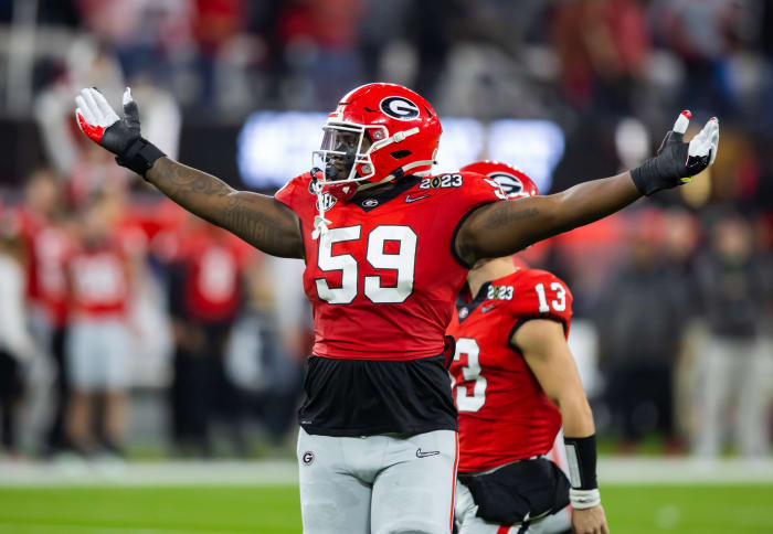 Georgia Bulldogs offensive lineman Broderick Jones holds his hands up and out to the sky
